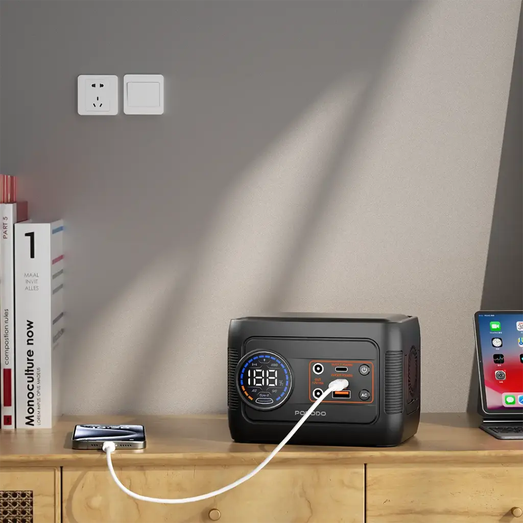 A Porodo Forcebase 150W Portable Power Station is placed on a wooden desk in a modern indoor setting.
