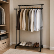 Adjustable Double Rail Garment Rack  with a top bar holding multiple hanging shirts and a lower shelf holding three pairs of shoes, placed in a beige room next to a wooden closet.