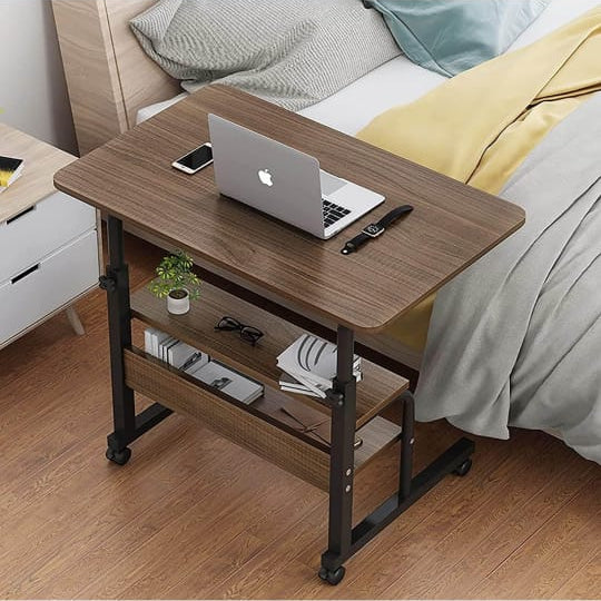 Adjustable Laptop Computer Desk with Bottom Shelf Placed Near Bed.