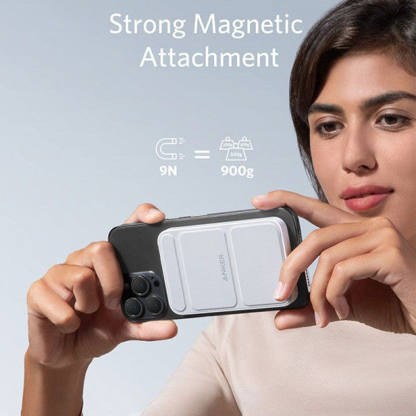 A lady is holding a mobile phone connected to a 5000 mAh Wireless Portable Charger