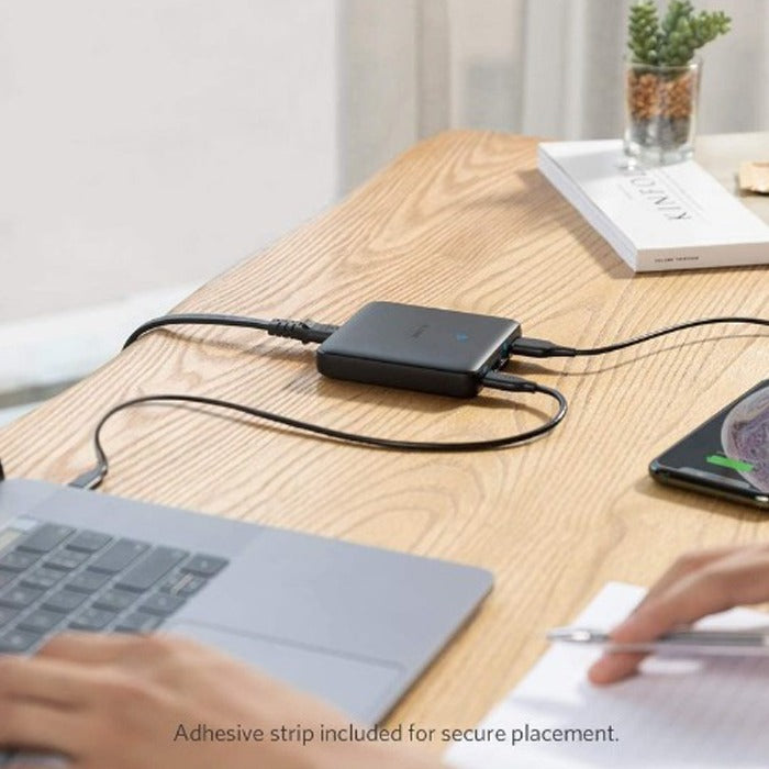 Anker PowerPort Atom 3 Slim 65W placed on the table next to a laptop