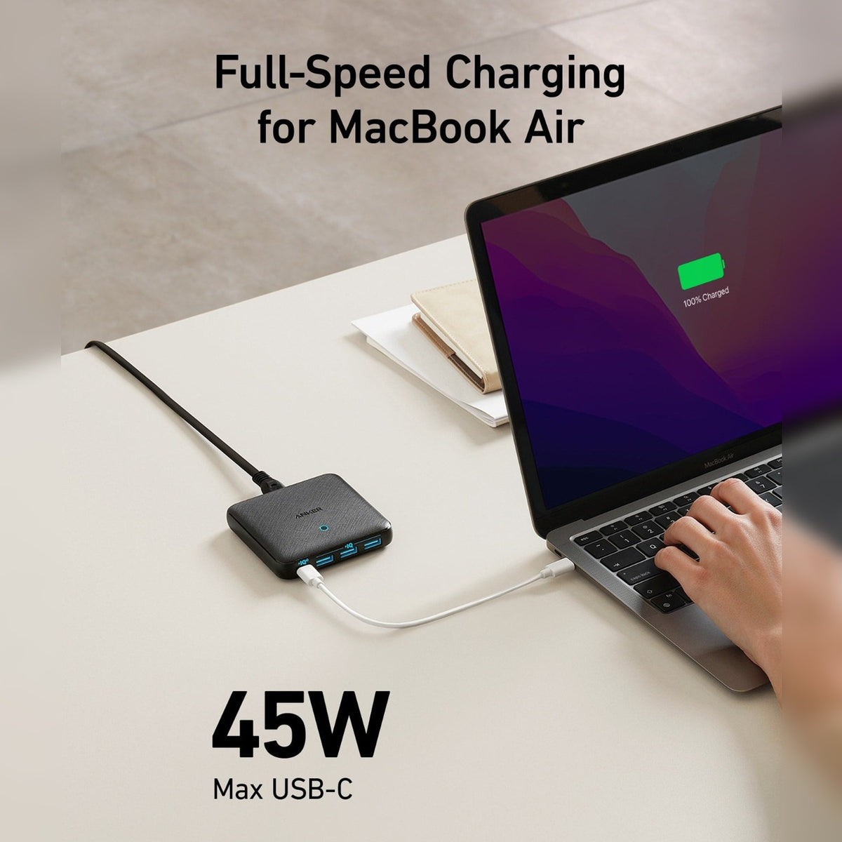 Anker PowerPort Atom 3 Slim 65W placed on the table next to a laptop