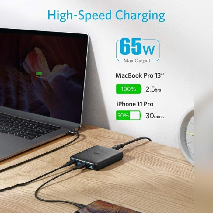 Anker PowerPort Atom 3 Slim 65W placed on the table next to a laptop