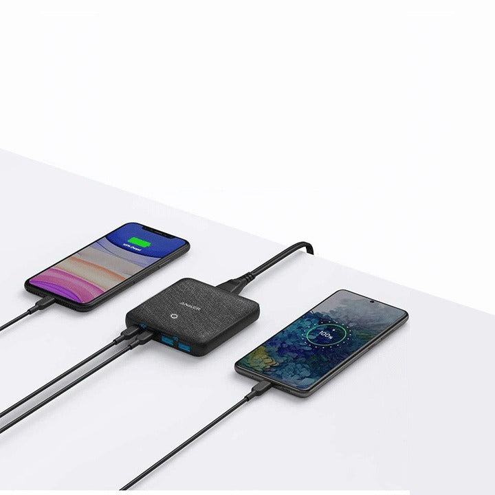 Anker PowerPort Atom III 63W Slim High-Speed Charger with 2 USB-C and 2 USB-A Ports placed on the table next to the mobile phone, which is plugged into it