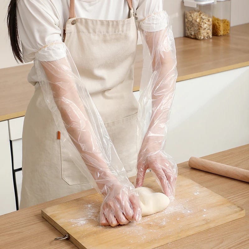 A Women is Making Dough By Wearing Disposable Anti- Slip Wear Long Sleeve Glove.