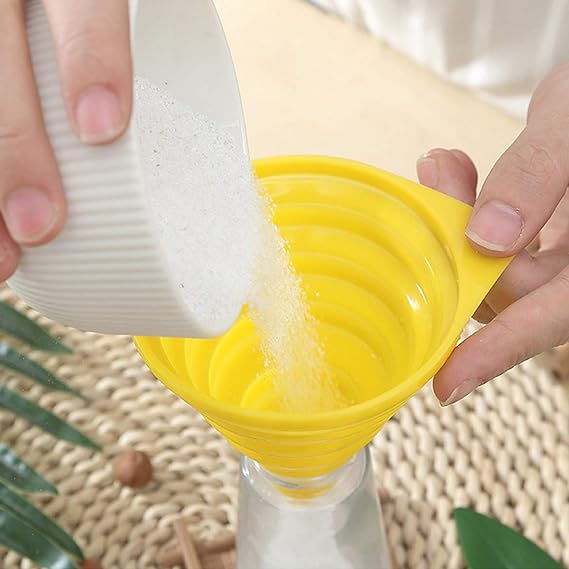 A person is pouring sugar into a bottle with the help of a Silicone Telescopic Collapsible Mini Funnel