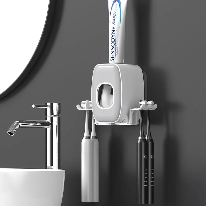 Automatic Toothpaste Dispenser Hanged On the Wall With Brushes and Toothpaste Are Placed On it.