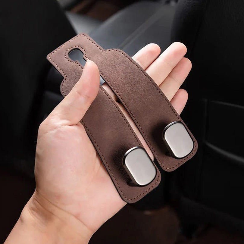 A Person is Holding Car Headrest Hanging Hook.