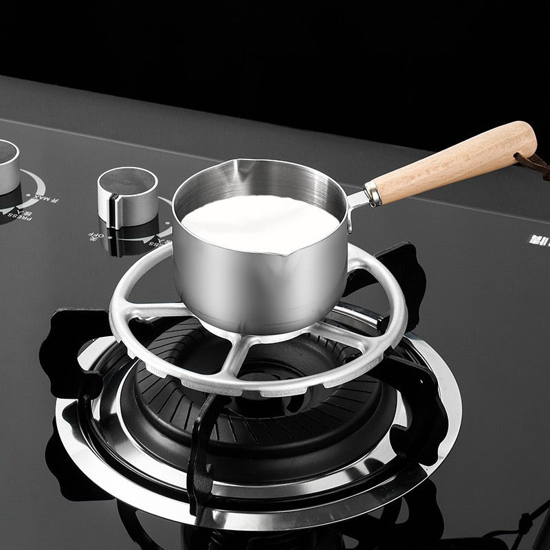 A pot of milk on a metal support kitchen gas stove bracket
