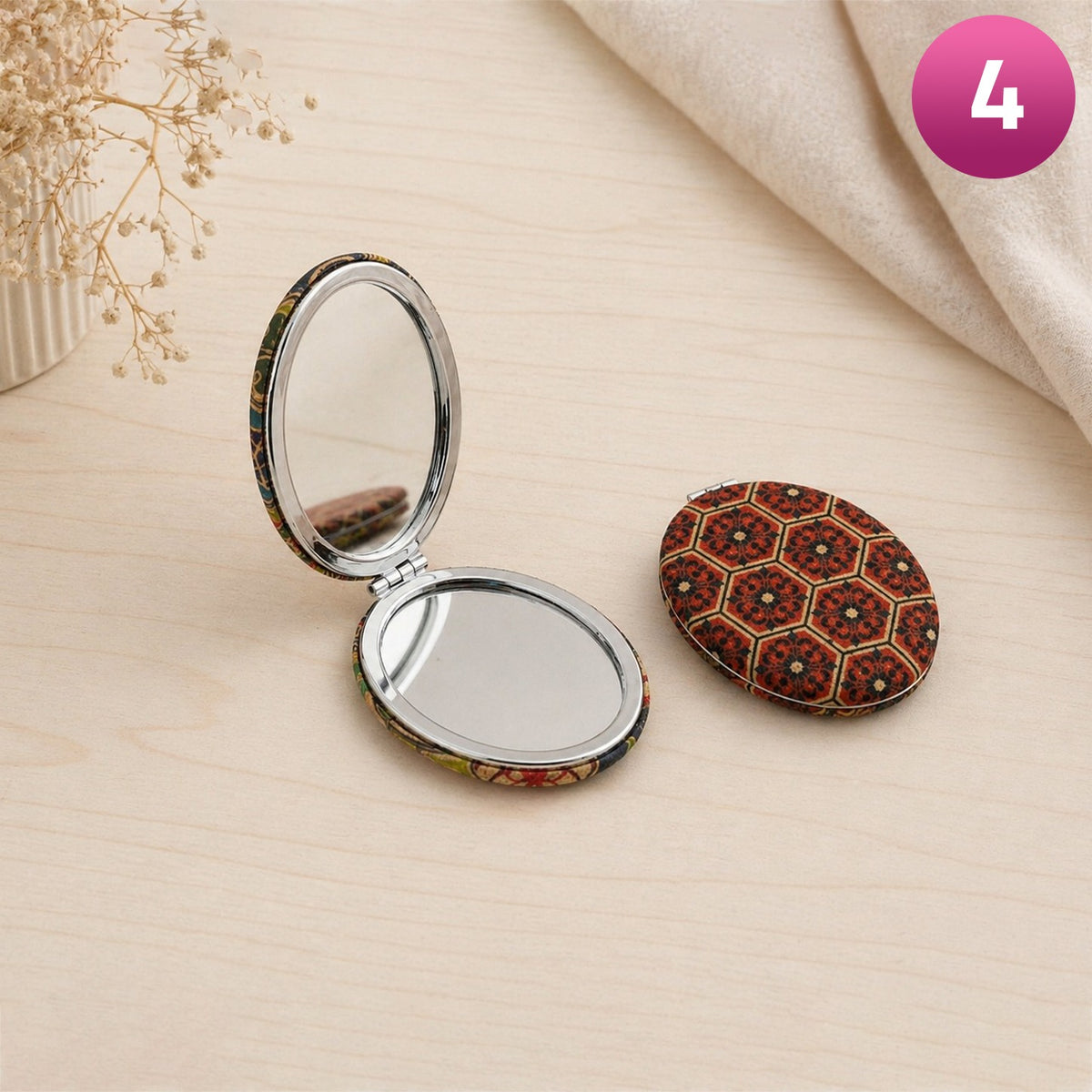 Compact mirror with decorative case on a beige surface