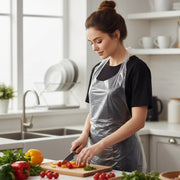 Woman wearing Disposable Waterproof Plastic Apron and  preparing vegetables in a kitchen
