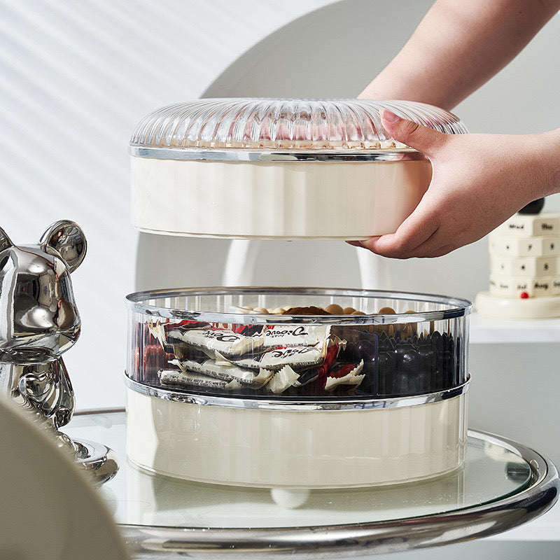 A Person is Picking Candy From Multi-Layer Snack Storage Container With Lid.