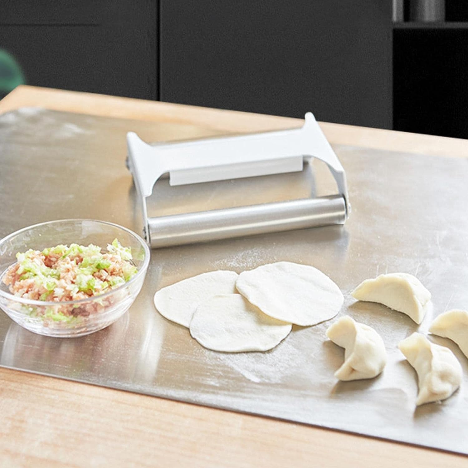 Double-Sided Stainless Steel Dough Roller for Baking placed on the table next to some Dumplings and ingredients