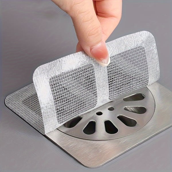 A Person is Sticking Drain Hair Catcher Mesh Sticker On The Bathroom Drain.