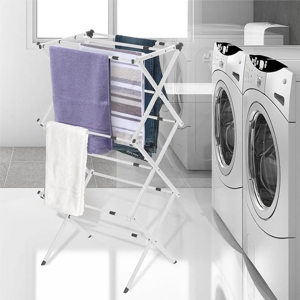 3-tier expandable clothes drying rack on a white floor near the washing machine, perfect for hanging clothes and towels