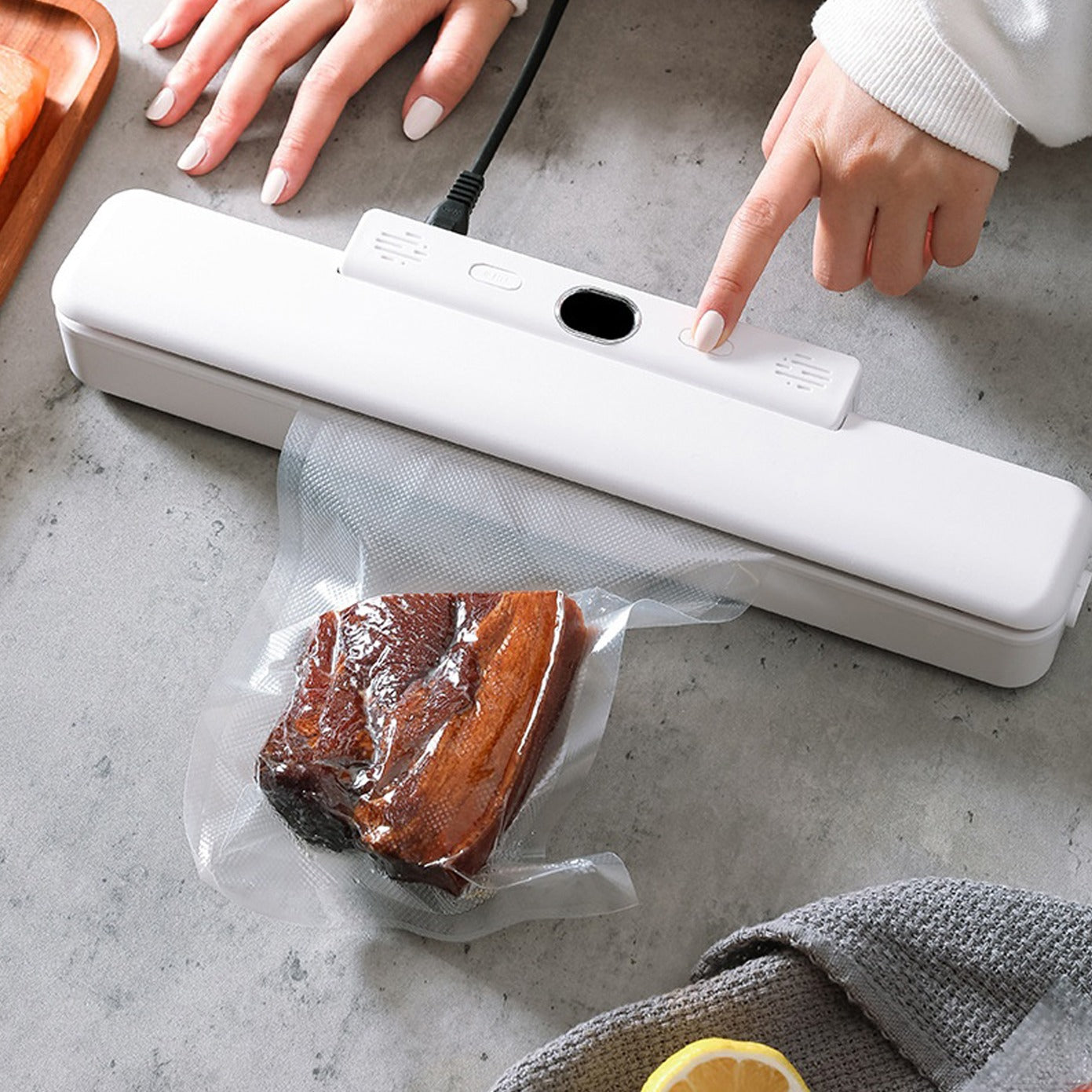 A person pressing the switch of the Automatic Food Vacuum Sealer