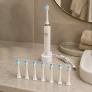 Electric toothbrush with multiple brush heads on a bathroom counter