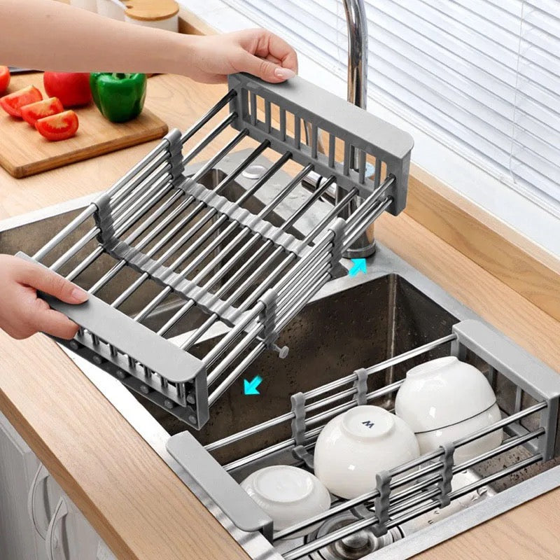 Someone pulling an expandable dish drying and washing basket