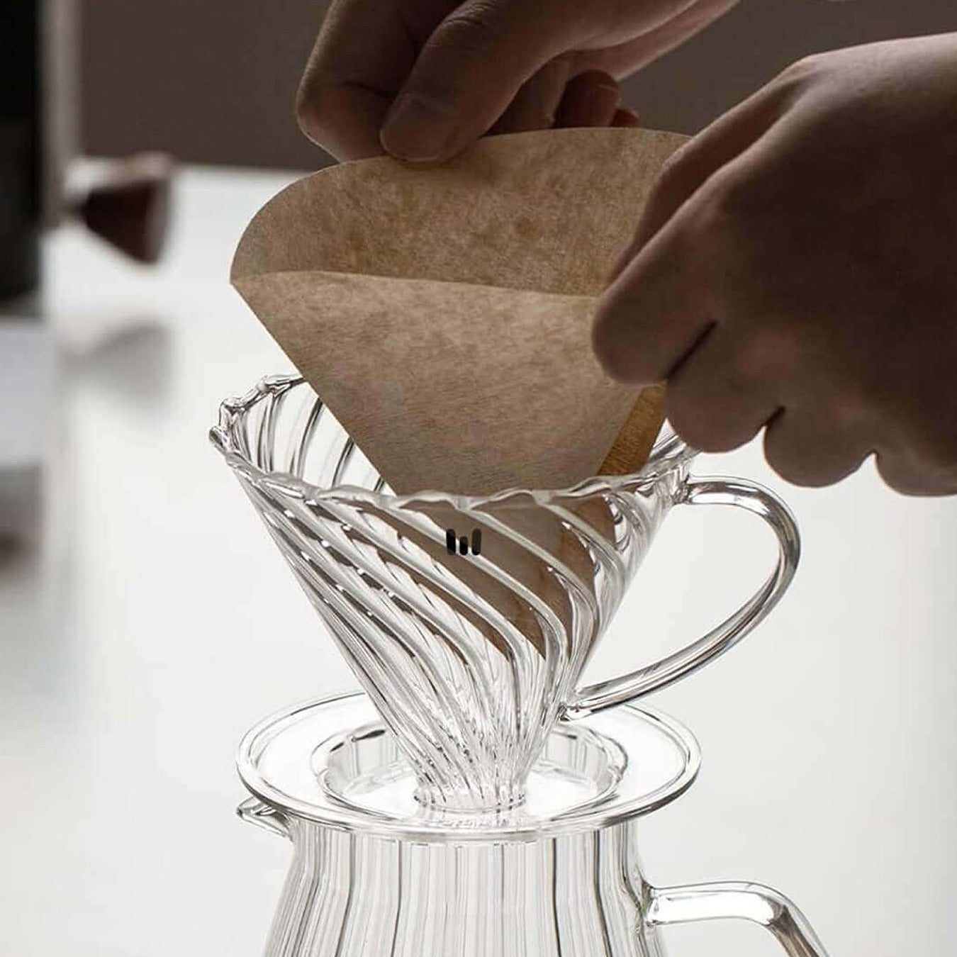A Person is Placing Filter Above Macnoa MacV Drip Coffee Dripper.