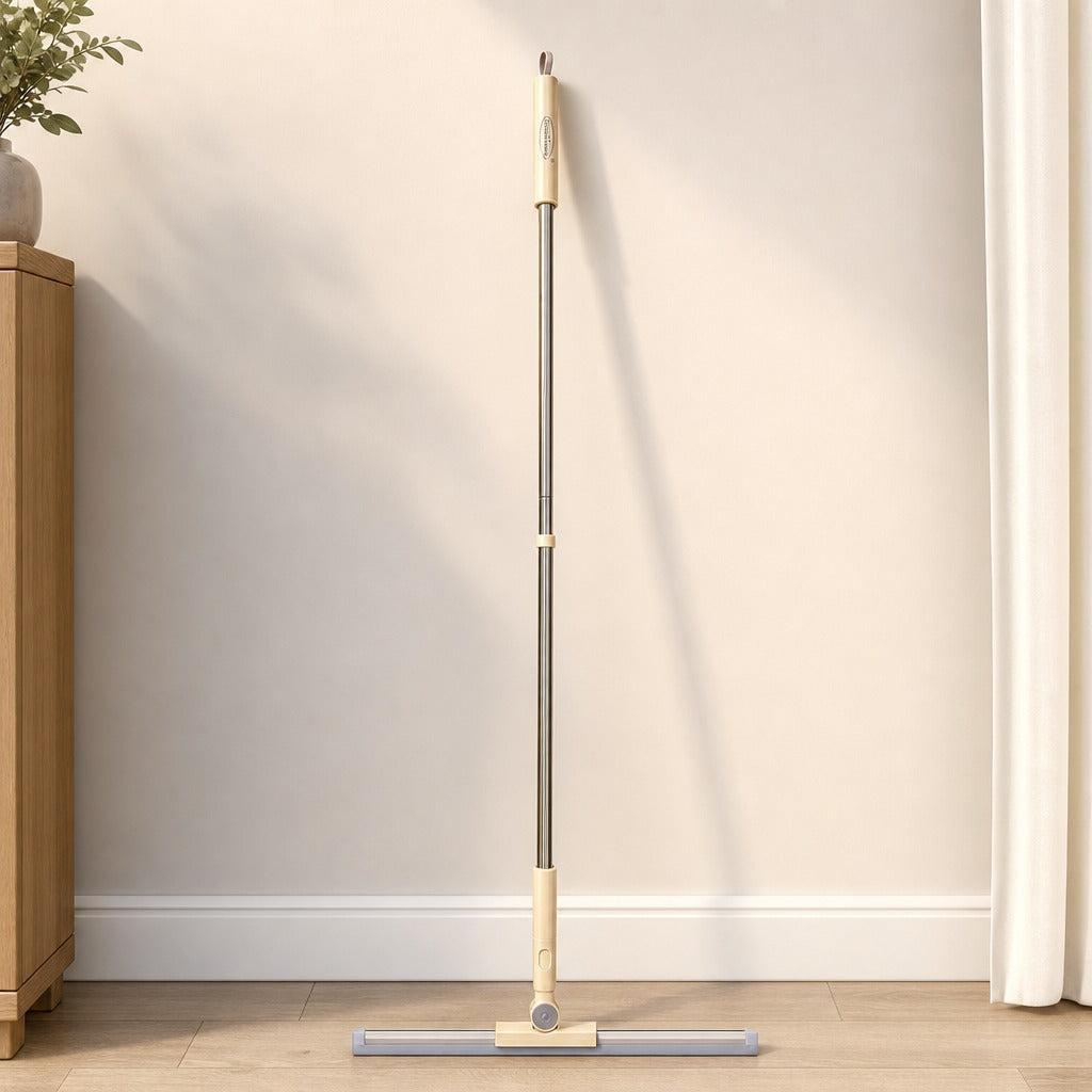 Floor Scraper with Long Handle eaning against a wall in a room with wooden flooring and a plant.