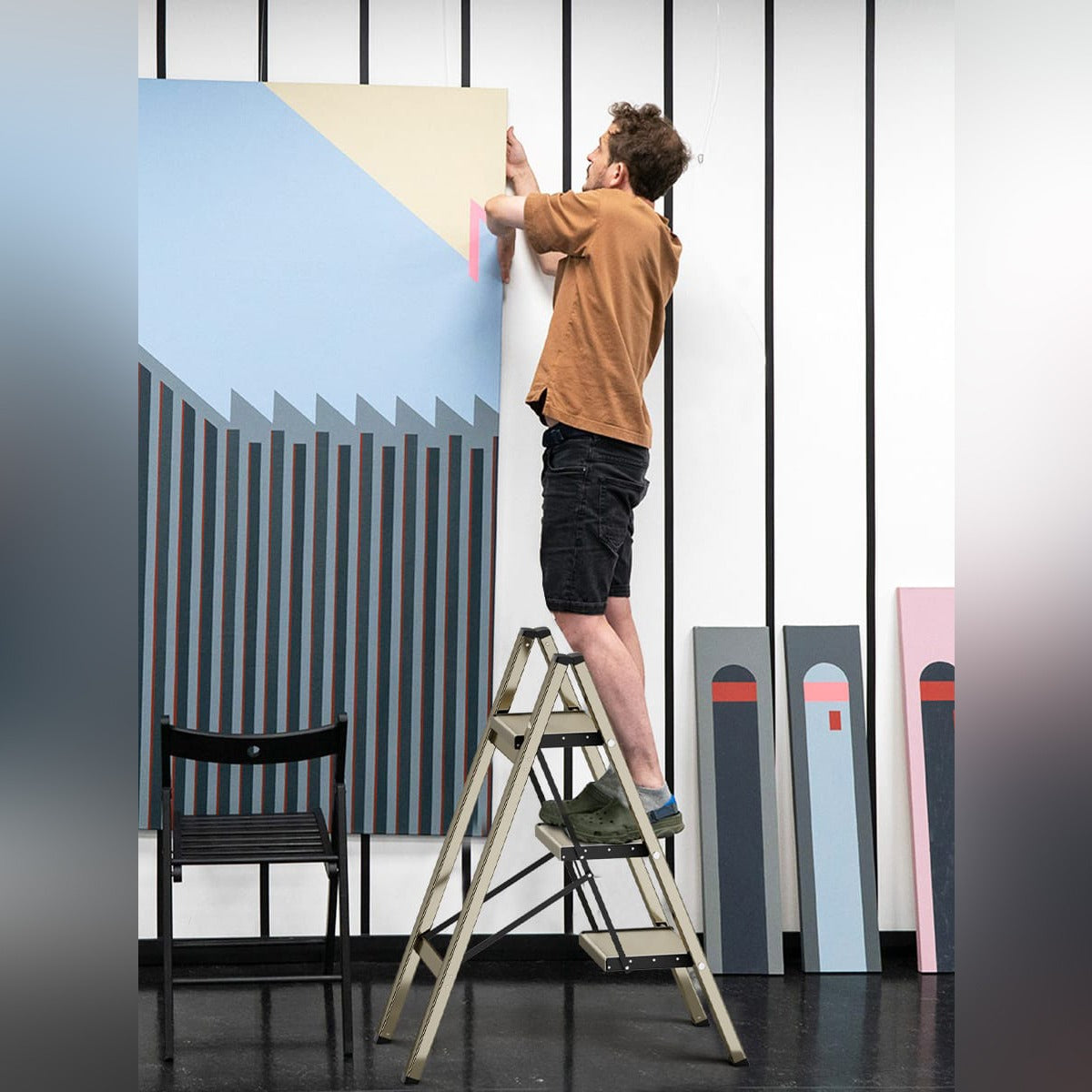 A Man is Stepping On The Foldable 3-Step Stool Ladder.