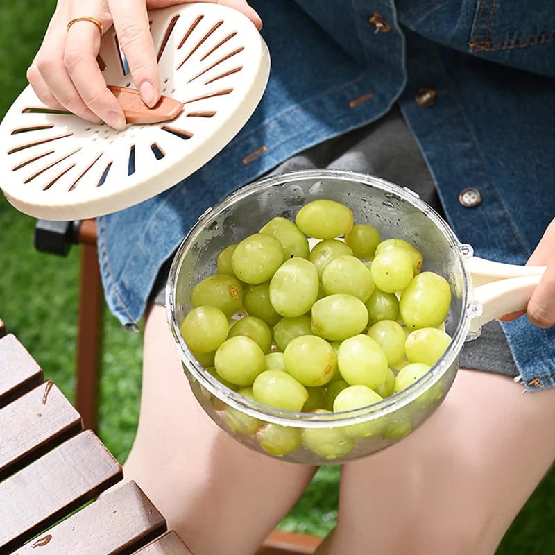 A Person is Holding Fruit Drain Basket With Fruits.