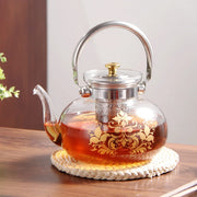 A Glass Tea & Coffee Pot with Tea Placed on a Table.
