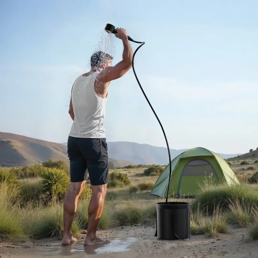 Man showering outdoors with a Green Lion Portable Camping Shower with a tent in the background