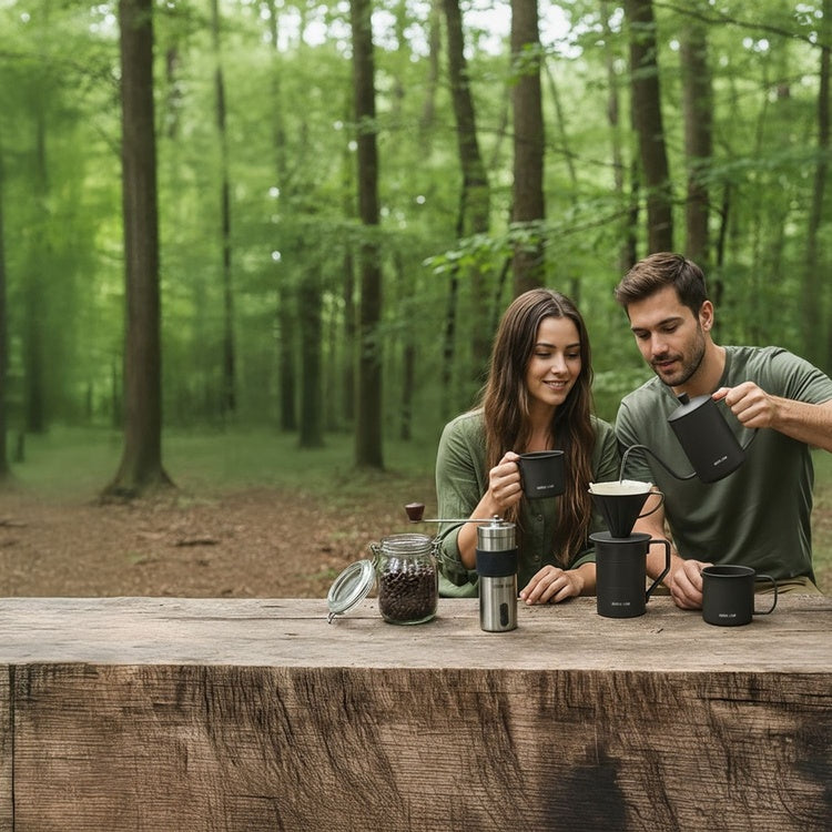 Two people making coffee use the Green Lion V-60 Pro Coffee Maker Set outdoors in a forest setting.
