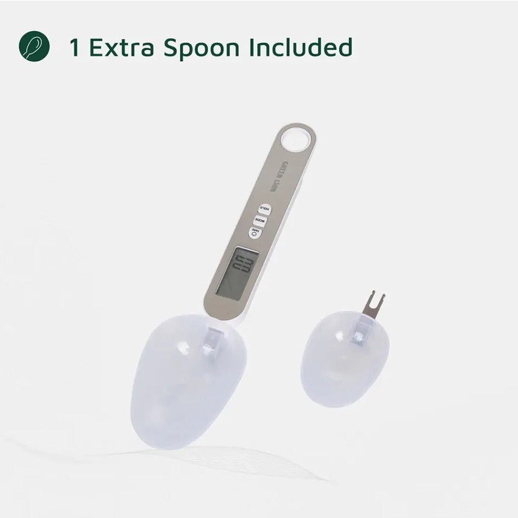 A Green Lion digital measuring spoon scale with an extra detachable spoon, featuring an LCD display and control buttons, shown on a white background.
