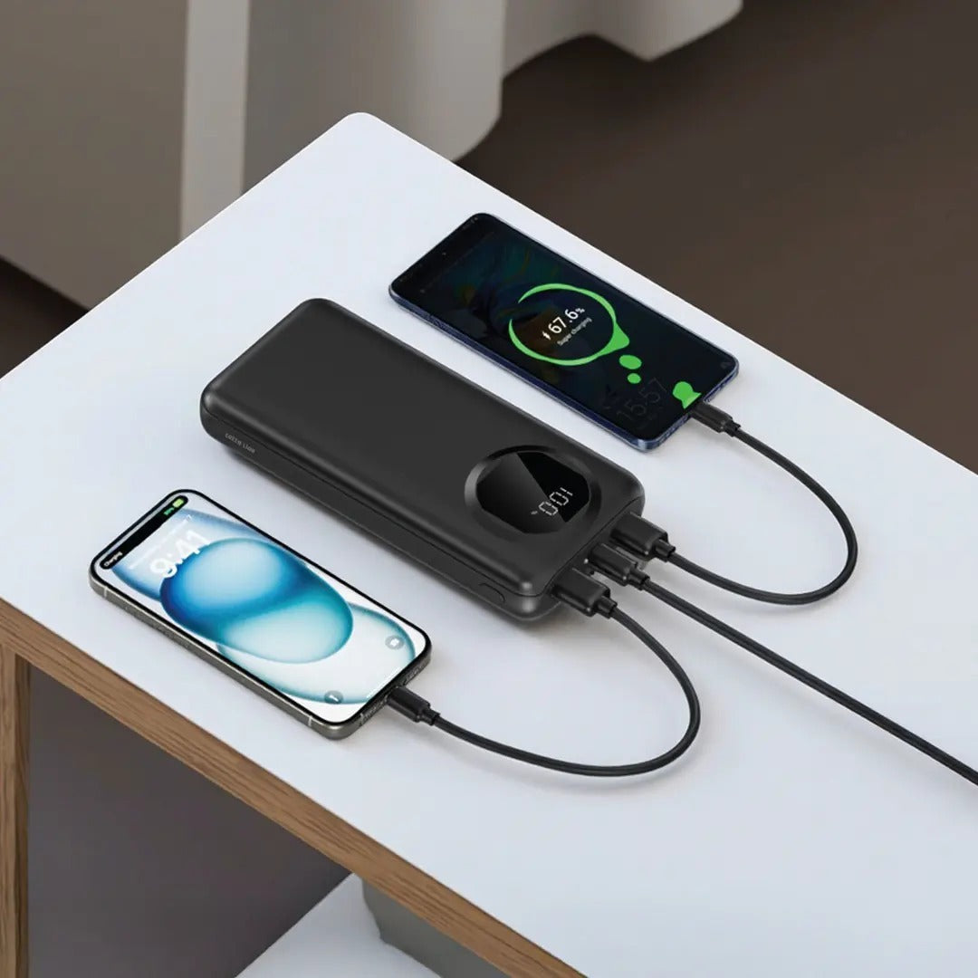 Two smartphones are charging from a Green Lion Nairo 20000mAh Power Bank on a white surface.