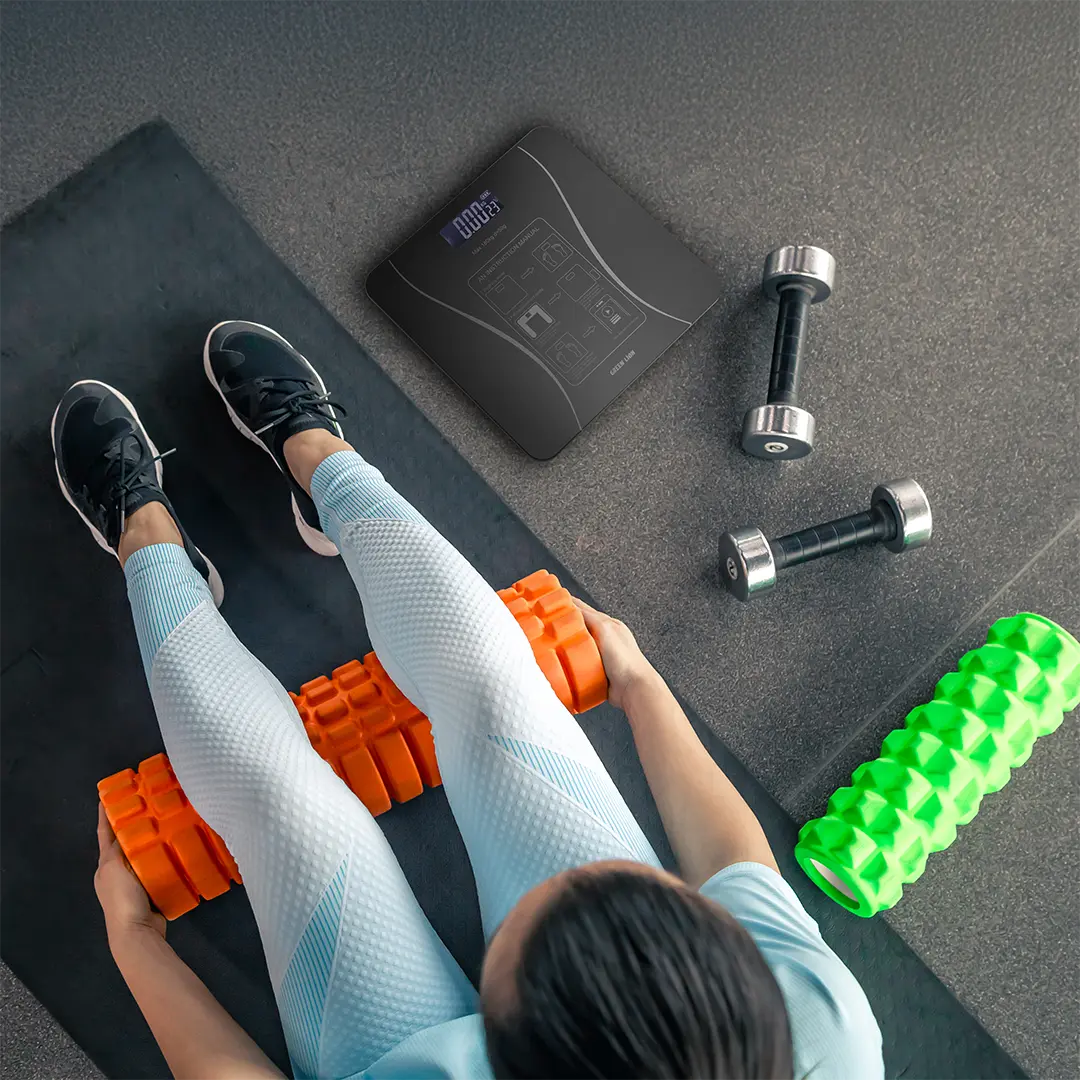 A Person is Working Out and Placed Green Lion Smart Body Scale Liite Next to Her.