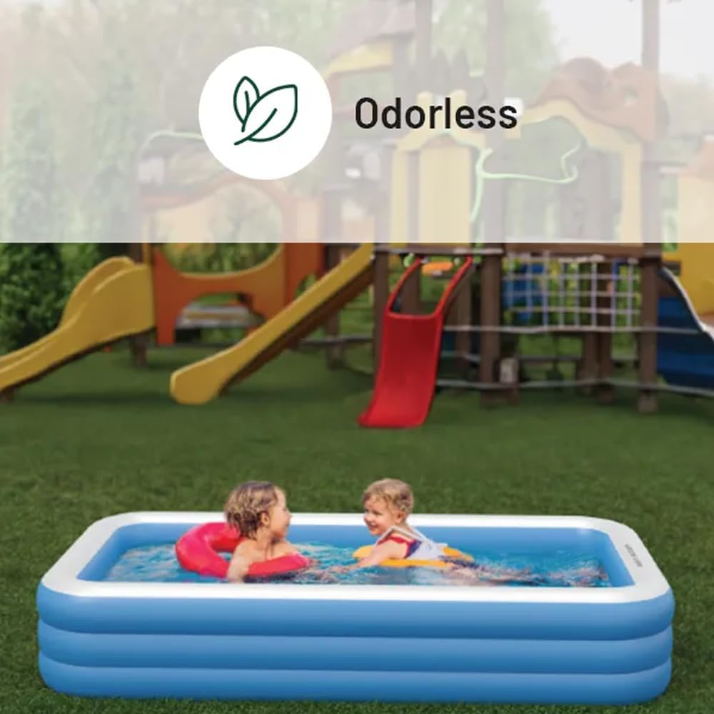 Two children happily playing in a Green Lion Inflatable Pool placed on a grassy lawn with a playground in the background. The pool is filled with water, and the kids are using float rings