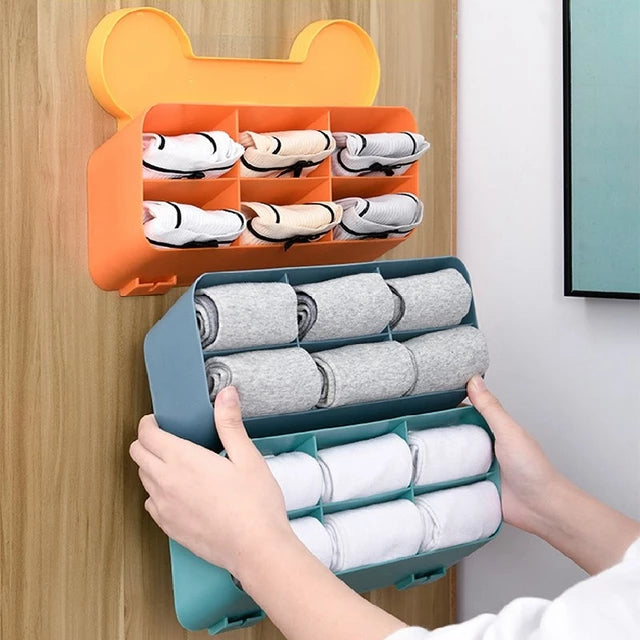 a person holding a Wall-mounted cloths Organizer with folded clothes 