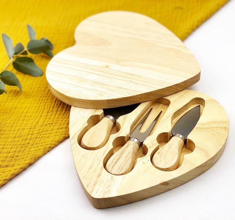 Heart-shaped wooden cheese board with built-in knife storage and serving area.