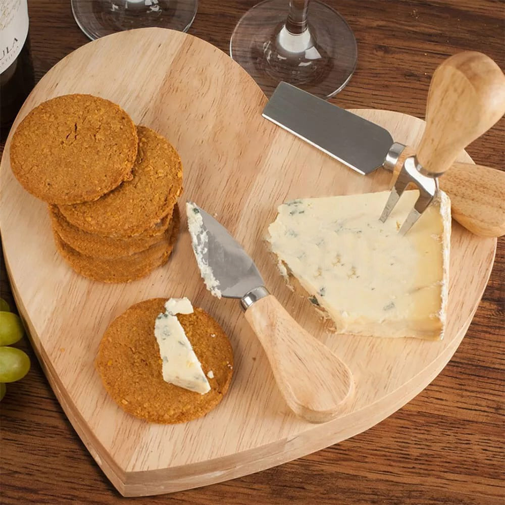 Heart-shaped wooden cheese board with built-in knife storage and served cheese and crackers.