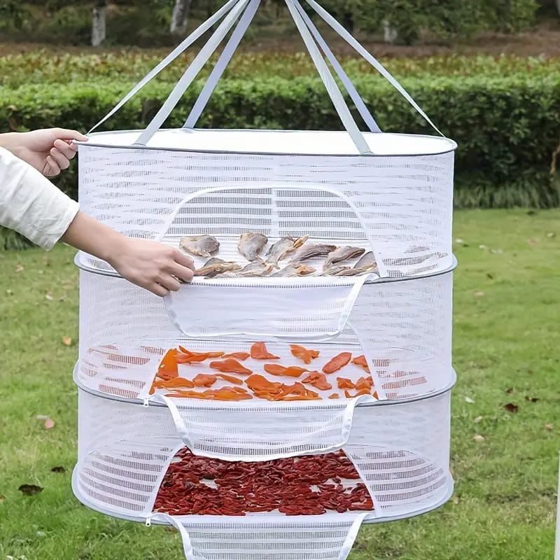 A Women is Placing Food Items in a Herb Drying Rack Net.