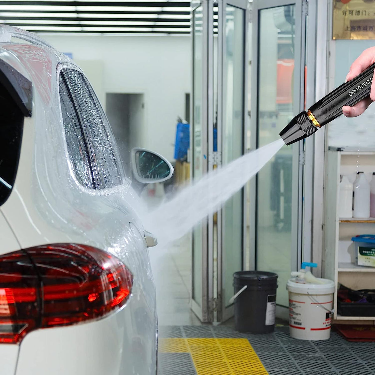 A Person is Washing Car Using High Pressure Car Washing Water Spray Gun Set.