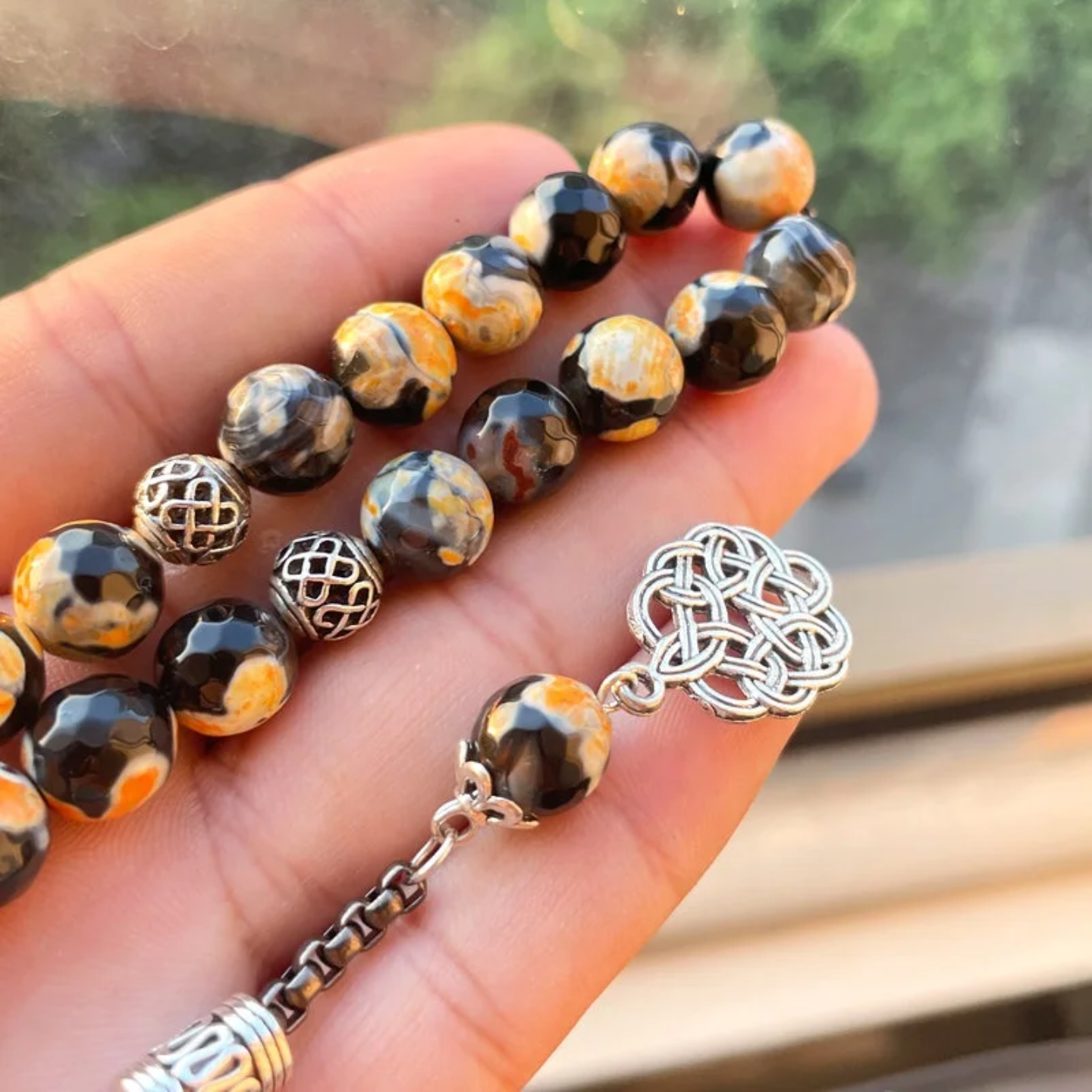 A Person is Holding Islamic Tasbih Prayer Beads.