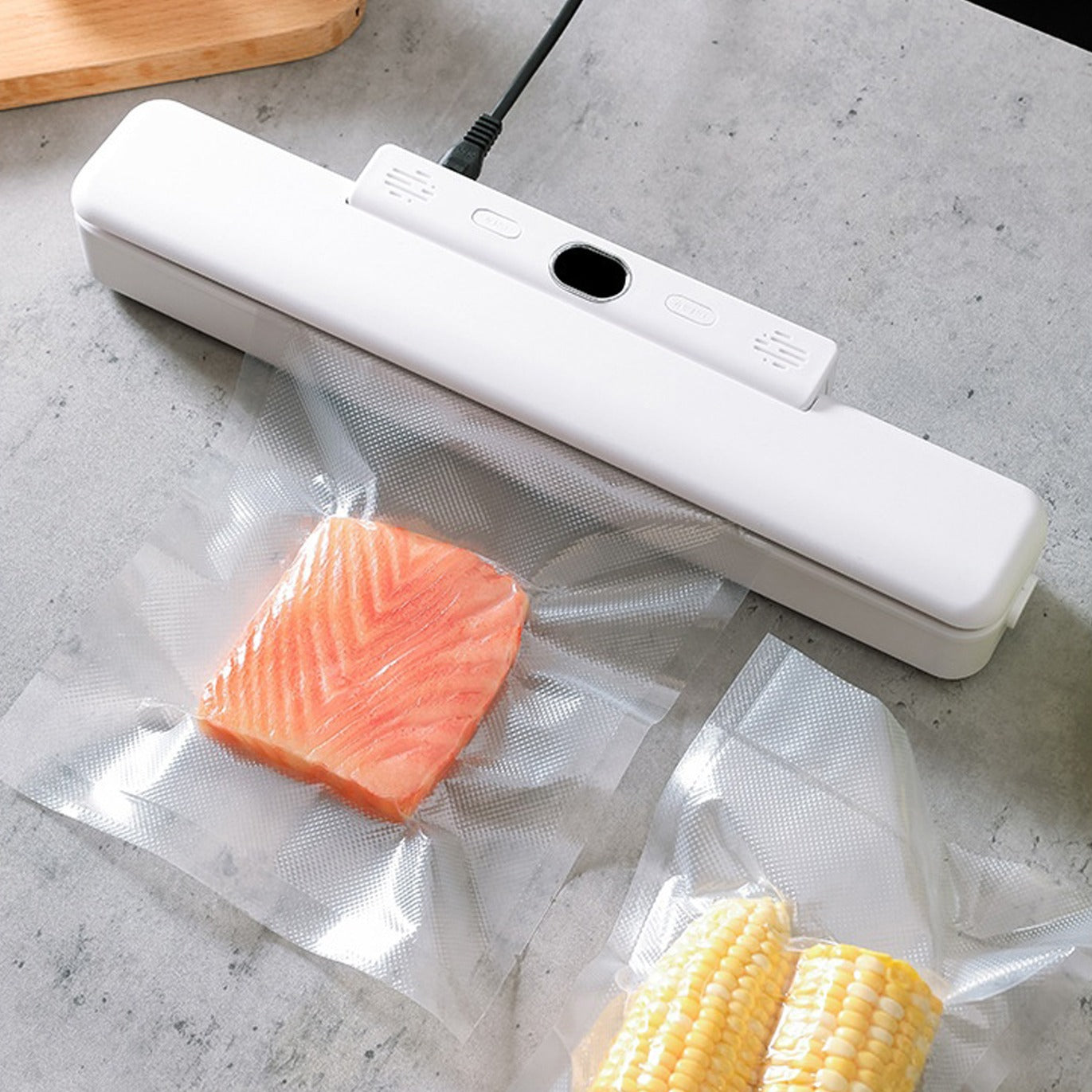Automatic Food Vacuum Sealer placed on the table next to some covers that were sealed with it