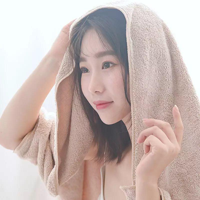 A lady using a bath towel set for kids and adults