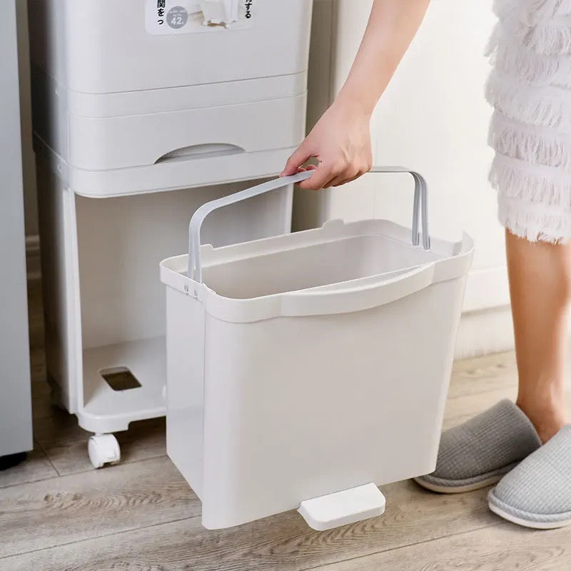 A woman holds a large garbage trash can