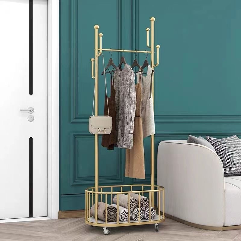 A Classic Minimalist Modern Metal Clothing Stand Wardrobe Garment Storage Rack with wheels is placed on the floor, adorned with dresses and bags next to the sofa