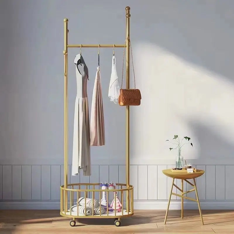 A Classic Minimalist Modern Metal Clothing Stand Wardrobe Garment Storage Rack with wheels is placed on the floor, adorned with dresses and bags
