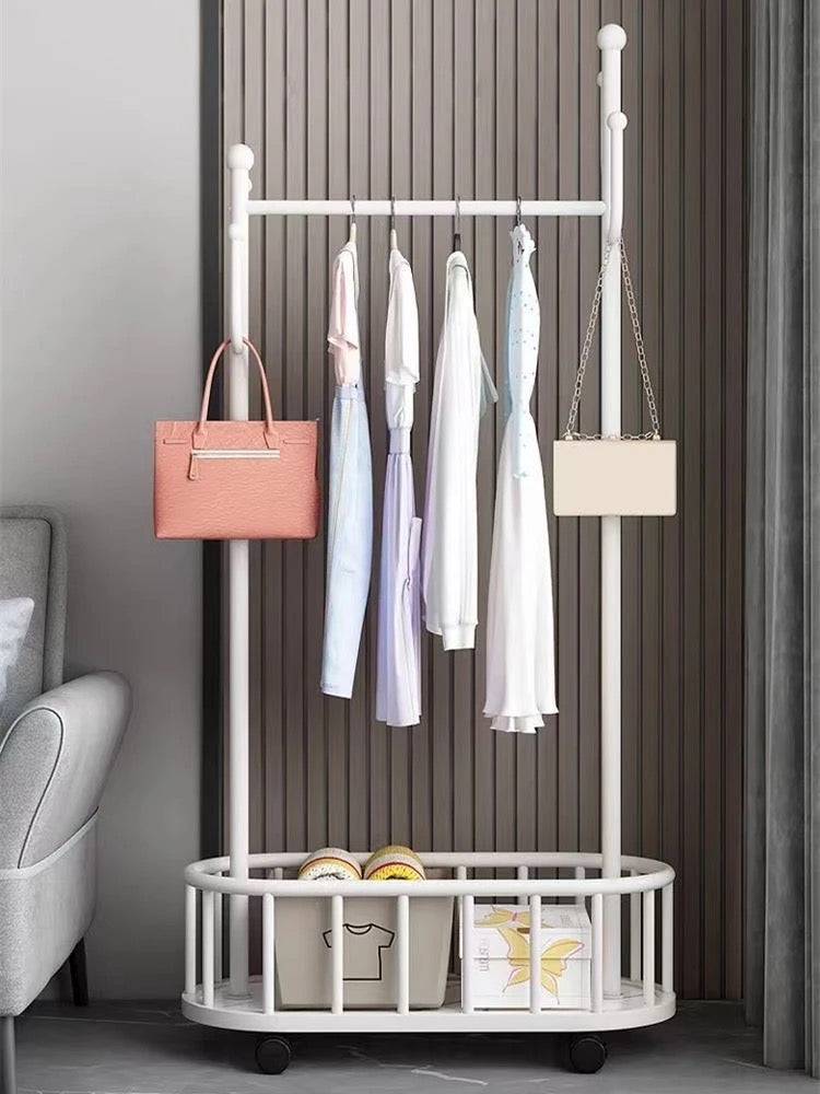 A Classic Minimalist Modern Metal Clothing Stand Wardrobe Garment Storage Rack with wheels is placed on the floor, adorned with dresses and bags