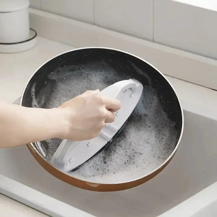 Someone cleaning a pan with Folding Sponge Cleaning Brush