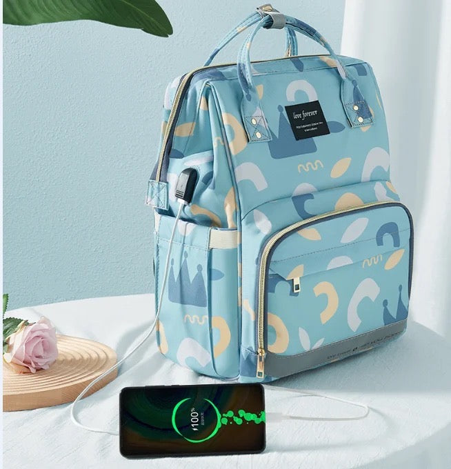 Stay organized with this fashionable blue and white patterned diaper bag, equipped with a bottle holder and designed as a waterproof mummy backpack for hassle-free travel.
