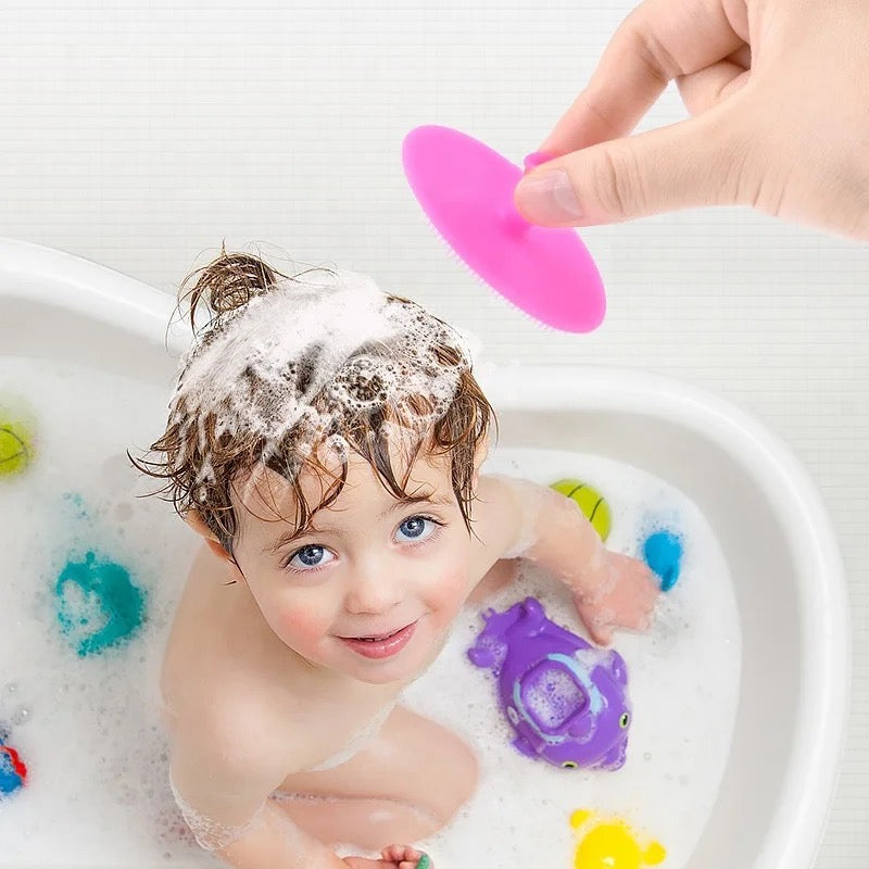  A baby is being bathed with a blue sponge using the Kids Soft Silicone Shower Brush, a gentle and effective tool for deep pore cleaning and exfoliating skin care