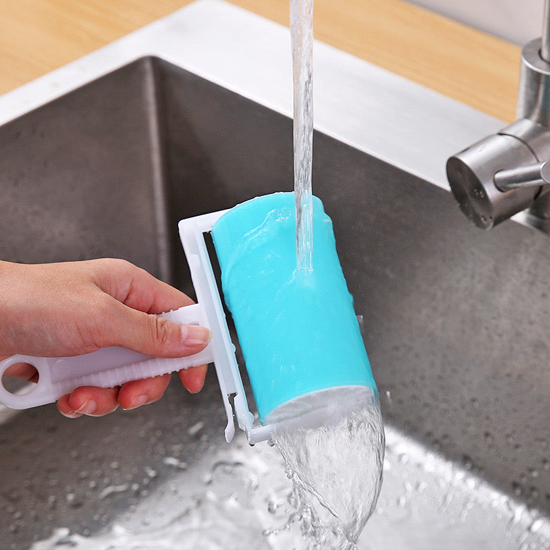 A person washing a Blue color reusable lint remover in a sink