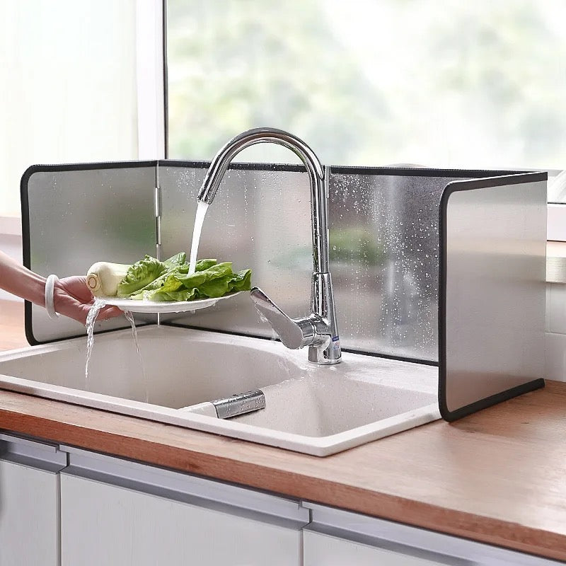 a person washing vegetables in a sink with Gas Stove Oil-blocking Board